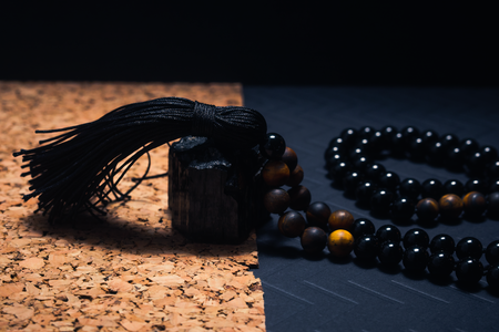 Black Onyx and Tiger's Eye beaded necklace with black tassel on cork background